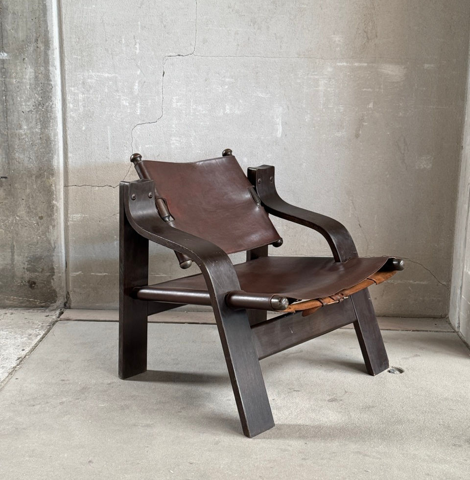 Three-quarter front view of the mid-century French brutalist leather sling armchair