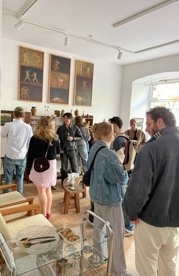 Visitors browsing through mid-century furniture and postmodern floor lamps at the vintage pop-up store event.