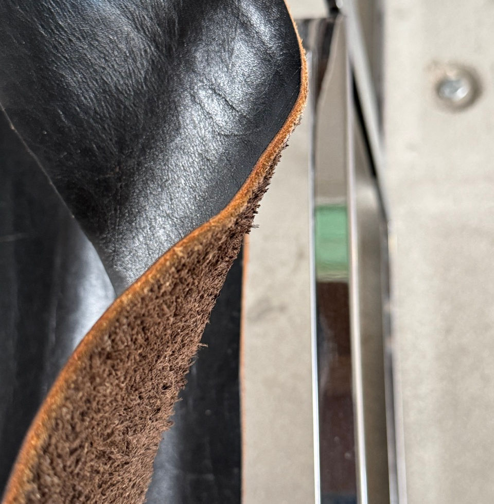 Macro shot highlighting the thick cut and authentic texture of the vintage black leather sling