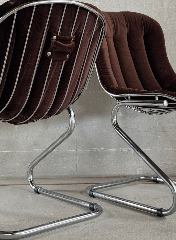 Close-up view of the tubular chrome frame and lower back details of the RIMA dining chairs