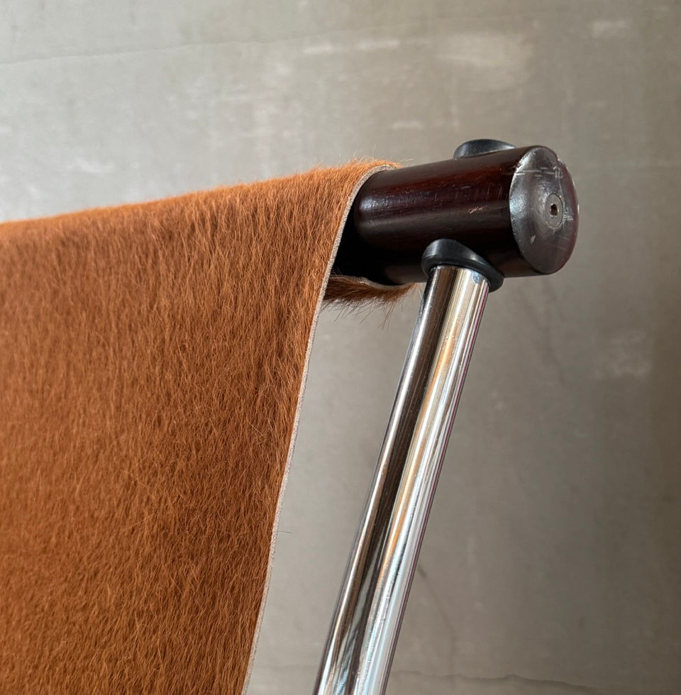 Detailed view of the sleek chrome-plated tubular steel frame and cowhide upholstery attachment