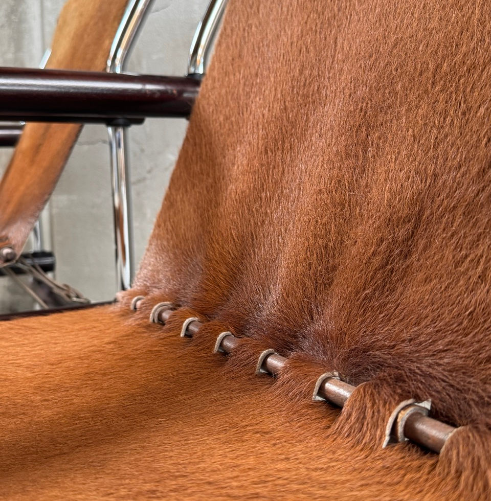 Detailed shot of the brown hair-on cowhide sling seat and structural wood joints