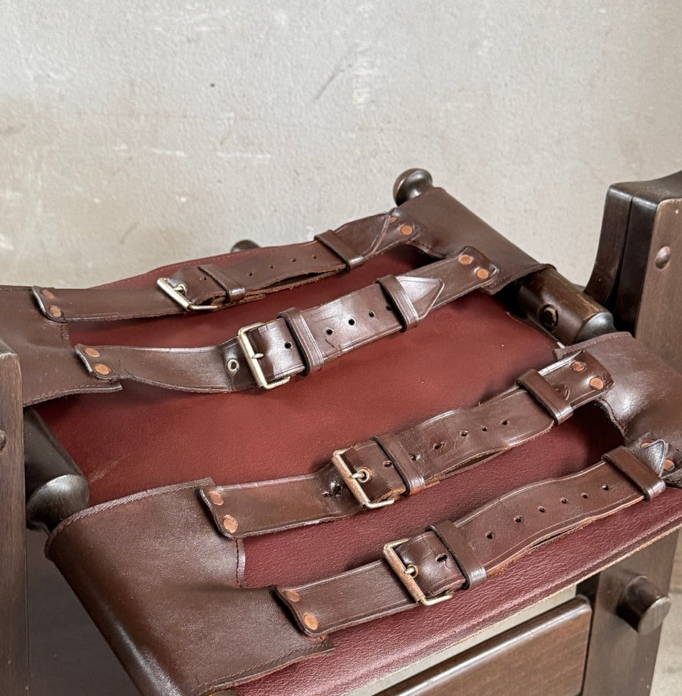 Close-up of the exposed brutalist buckle details on the underside of the leather seat