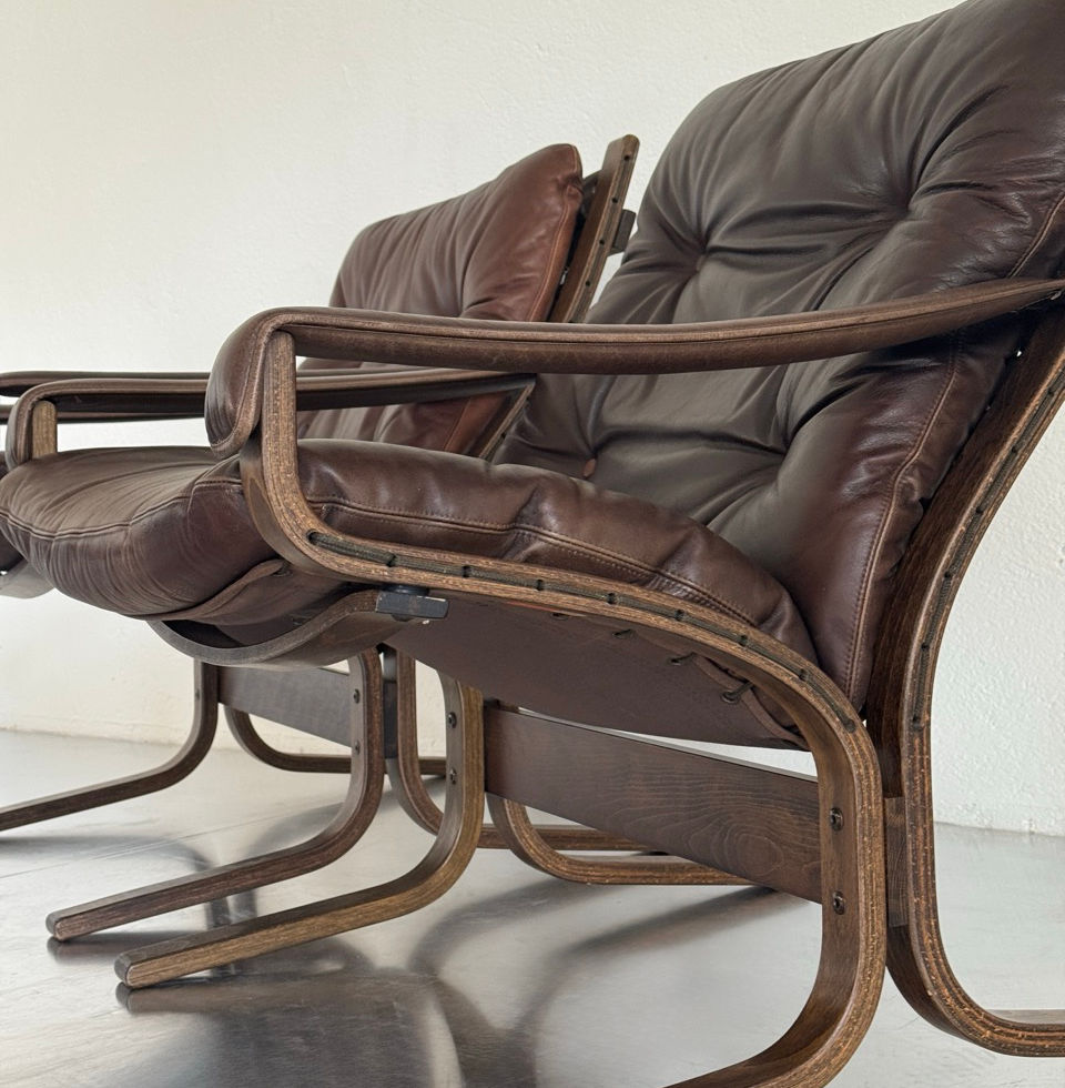 Side profile view of the mid-century Scandinavian bentwood frame and brown leather upholstery