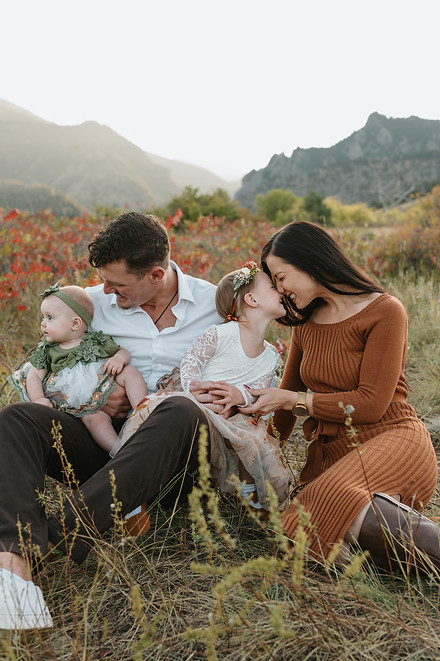 A family of four sits on the ground and poses during a family session in Boulder, Colorado. 