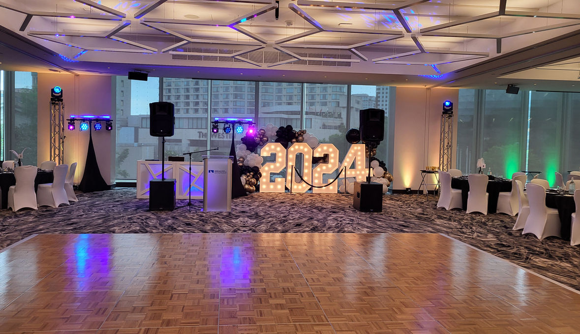 DJ Setup for a 2024 Prom. White DJ Facade with 2 light bars, 4 wash lights, 4 mini moving heads.