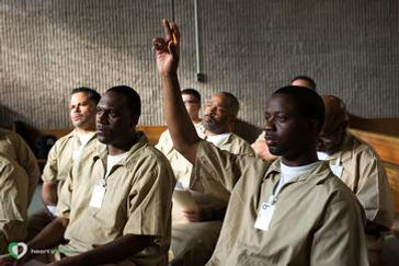 manRaisingHandPrisonClass.jpeg