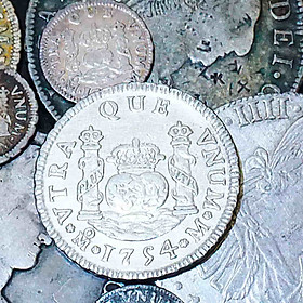 Collection of Spanish milled silver coins including pillar and bust types showing detailed engraving and uniform round planchets