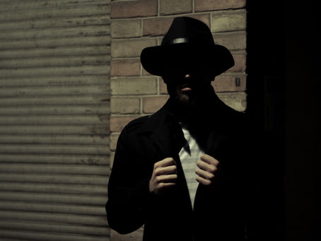 A shadowy figure in a dark alley. Possibly a spy.