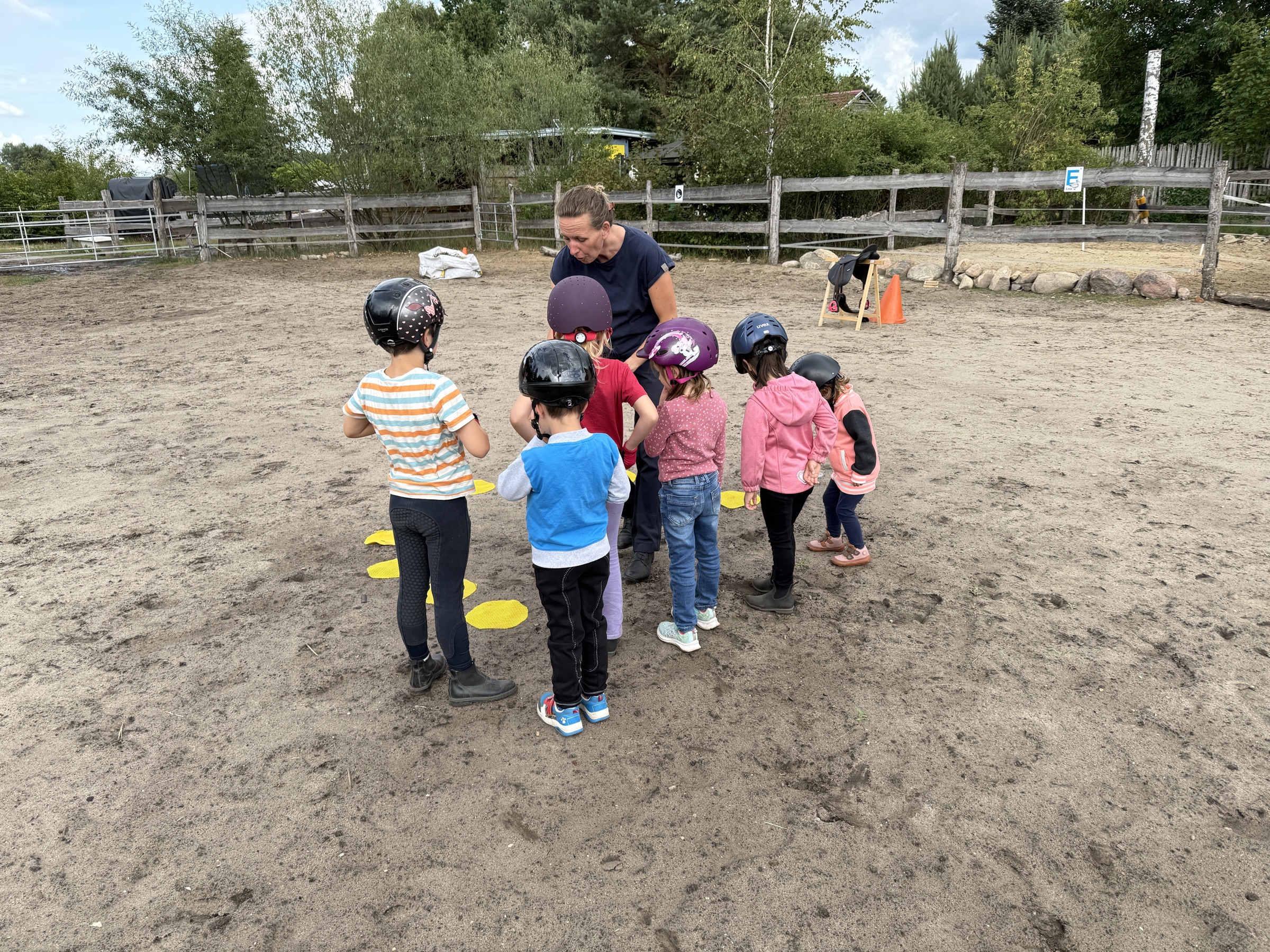 Kinder mit Ponys auf dem Reitplatz der Ponyschule