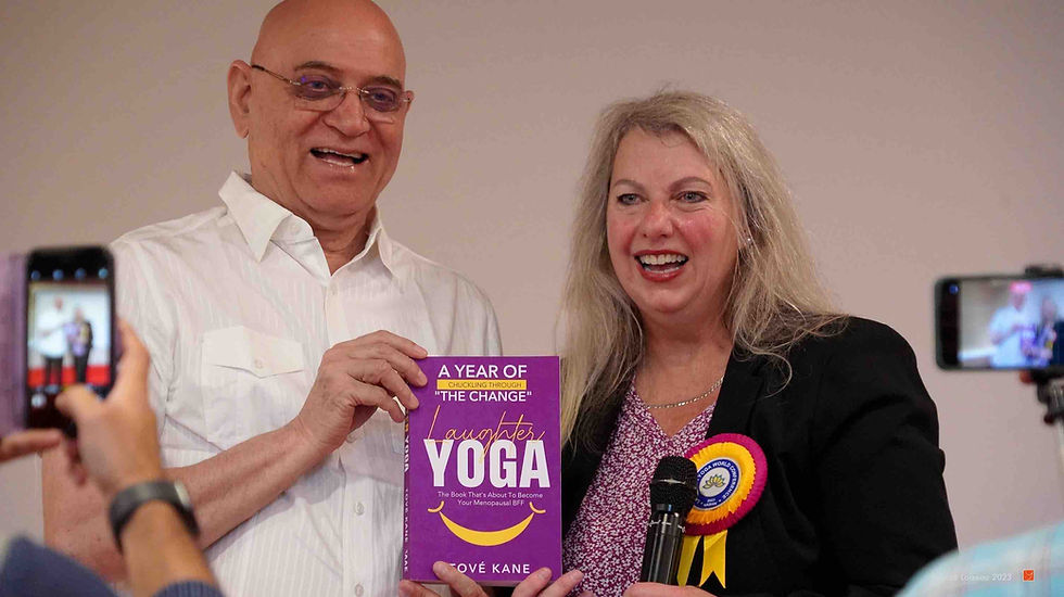 Dr Madan Kataria and Tové Kane holding copies of Laughter Yoga: A Year of Chuckling Through “The Change”