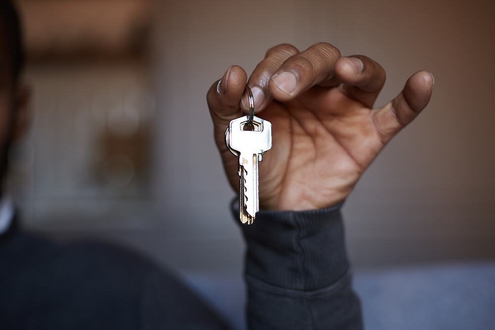 A black man handing over a set of keys to someone