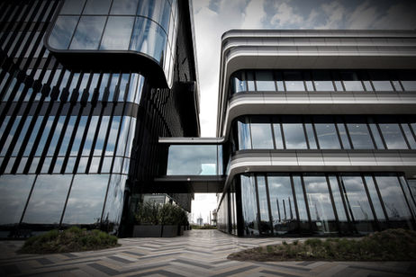 Exterieurfotografie van bedrijfspanden - Moderne kantoorgebouwen verbonden door loopbrug: bedrijfsfotografie