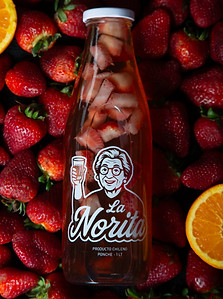 Botella de Clery La Norita encima de una cama de frutillas