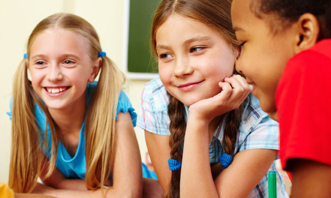 Children smiling in school in reference to our online primary school classes.