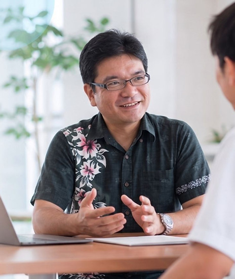 オフィスで笑顔で打ち合わせをする二人の男性社員