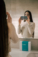 歯のパノラマ画像が映るスマホを持つ女性