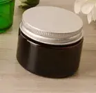 Miniatura: Contenedor de vidrio ámbar resistente al calor con tapa metálica negra hermética.
