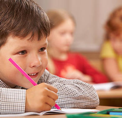 young boy writing in notebook