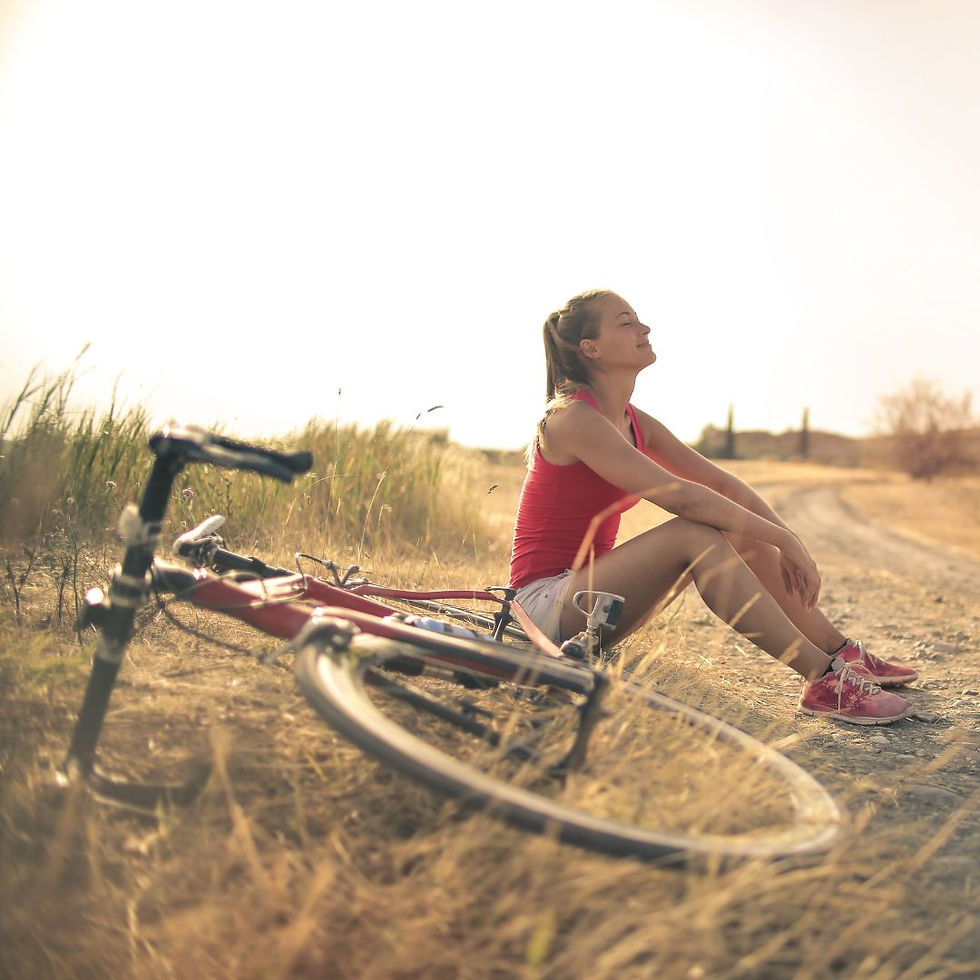 Woman resting beside her bike on a country path, pausing to reflect — symbolising that long-term results come from a reset, not just a jab.