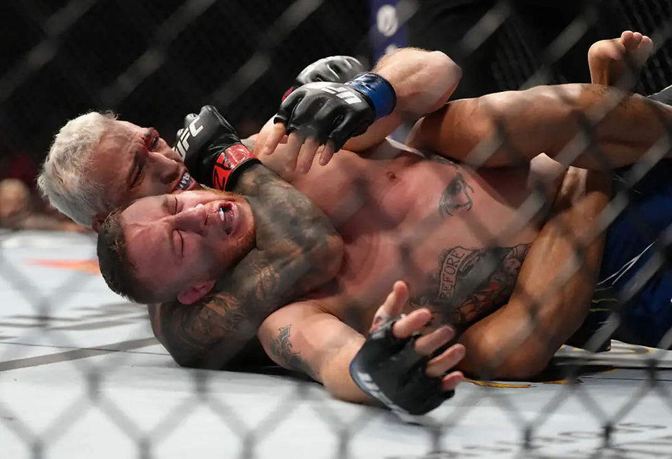 Two MMA fighters grapple in a cage. One applies a rear choke, both show intense emotion. The setting is an octagon with visible tattoos.
