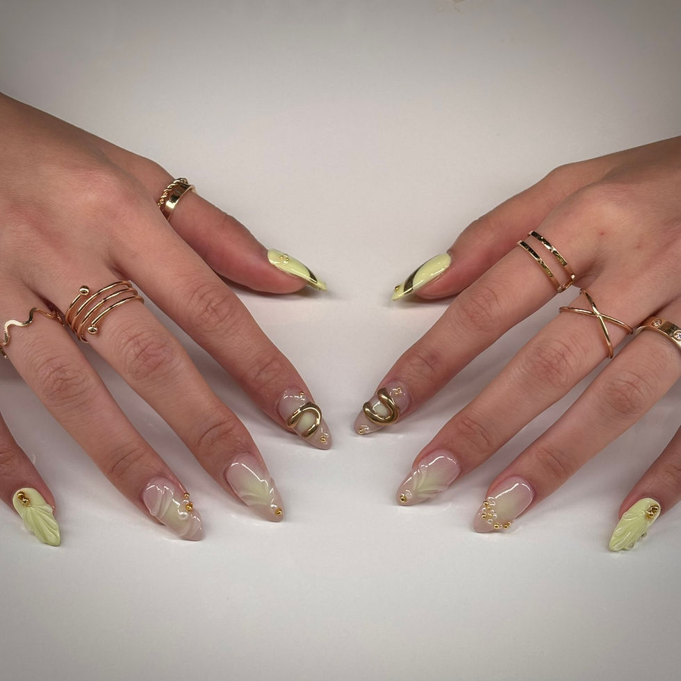 Pastel yellow nails with 3D swirls, gold accents, and pearls at Robson Nails, a nail salon near me in downtown Vancouver