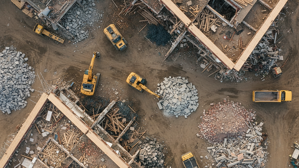 Vue en plongée d'un chantier de démolition avec des équipements lourds et des débris organisés