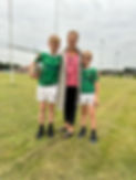 Mum and two rugby playing sons on a rugby pitch in front of rugby posts.jpg