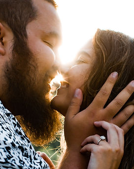 A photo of a couple with their nose touching during golden hour.