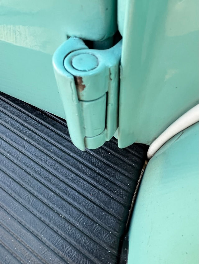 Paint chip pre-restoration on Vw door hinge