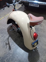 White custom pit bike with tan seat.