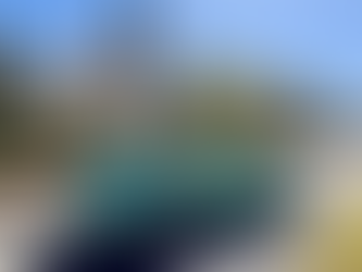 VW convertible in front of a Victorian Home