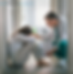 Medical professional consoling a woman sitting on the floor with her head between her legs.