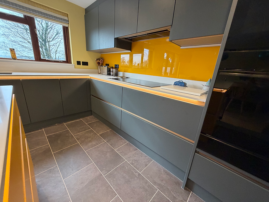 Grey fitted kitchen with bright yellow splashback