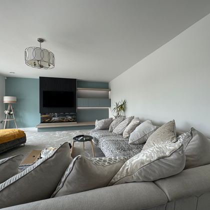Modern living room with gray sectional sofa and teal accent media wall