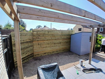 Garden shed installed in back garden and wooden fences