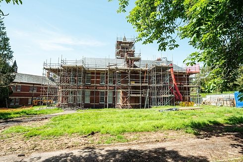 Scaffolding around a large home and green grass