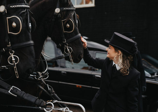One of the staff at John Brown and Daughter Funeral Services smoothing the nose of a horse 