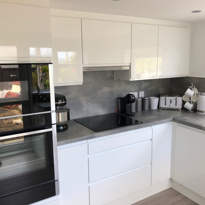 Modern white fitted kitchen with oven and hob