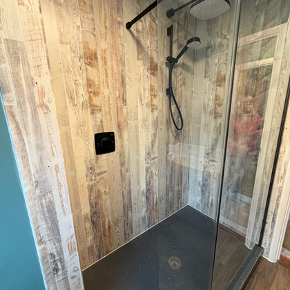 Walk-in shower with wood-look tiles and black fixtures