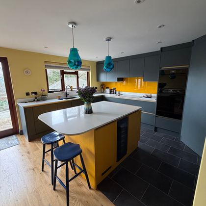 Modern fitted kitchen with yellow island and grey cabinets