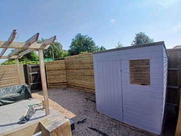 Garden shed installed in back garden and wooden fences