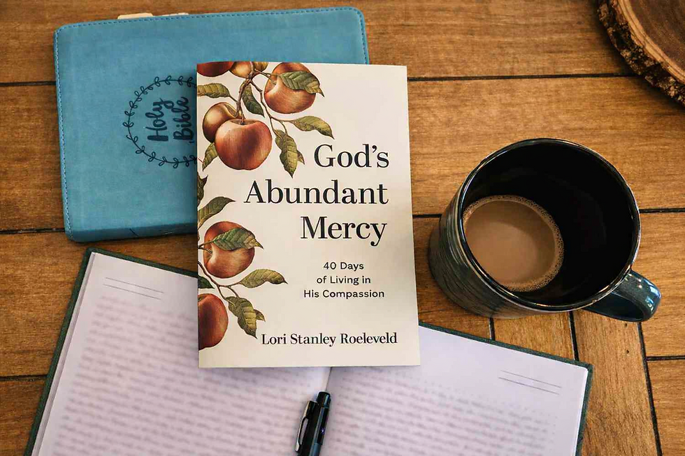 A book titled God's Abundant Mercy, a Bible, a journal, and a cup of coffee.