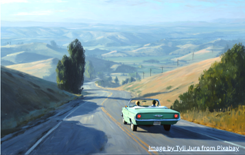 Two people in a convertible driving through rolling hills.
