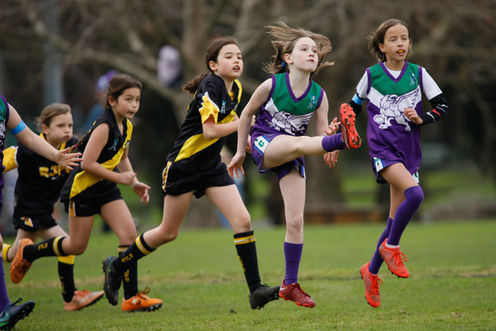 U10 Brunswick Girl player kicking the ball high