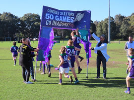 U12 brunswick Boys players running through banner