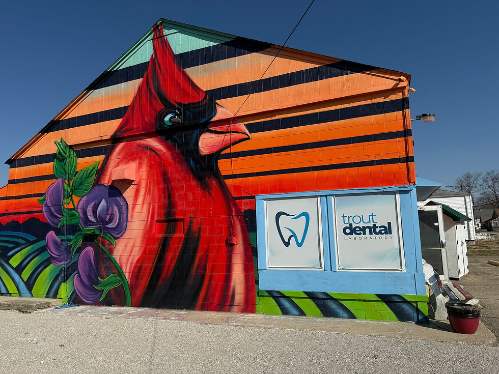 Trout Dental Laboratory decal on window of building painted with a cardinal and bean fields.