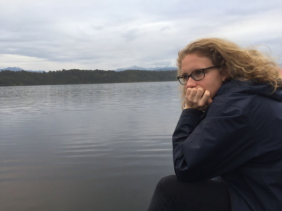 Woman enjoying a peaceful moment overlooking a lake during a New Zealand walking holiday, reflecting on making the most of life and travelling with confidence.