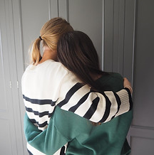 Two young women embracing, showing support and friendship