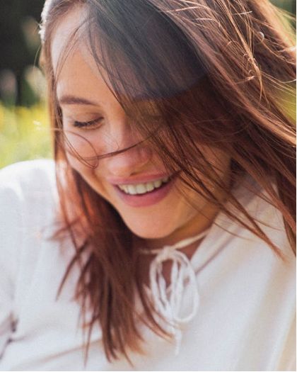 a smiling woman standing outdoors.